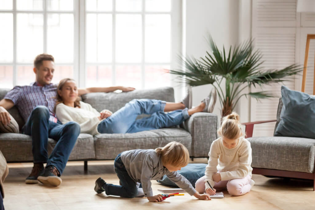 Children siblings playing drawing together while parents relaxing