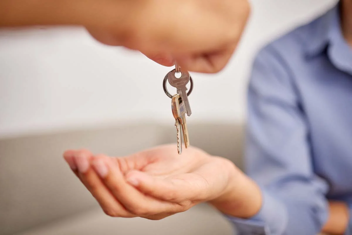 Professional host handing over keys to a guest at a short-term rental property