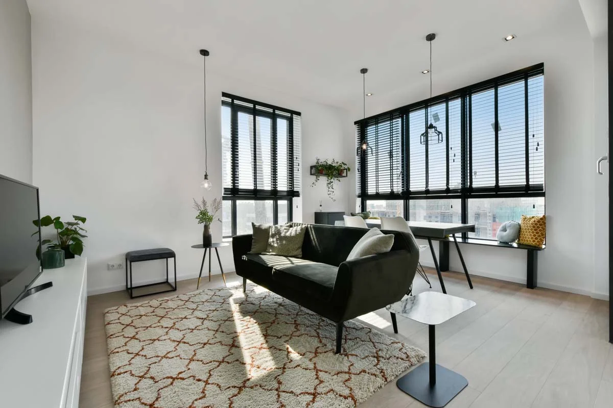 A bright, modern, and fully furnished living room in a luxury high-rise condo