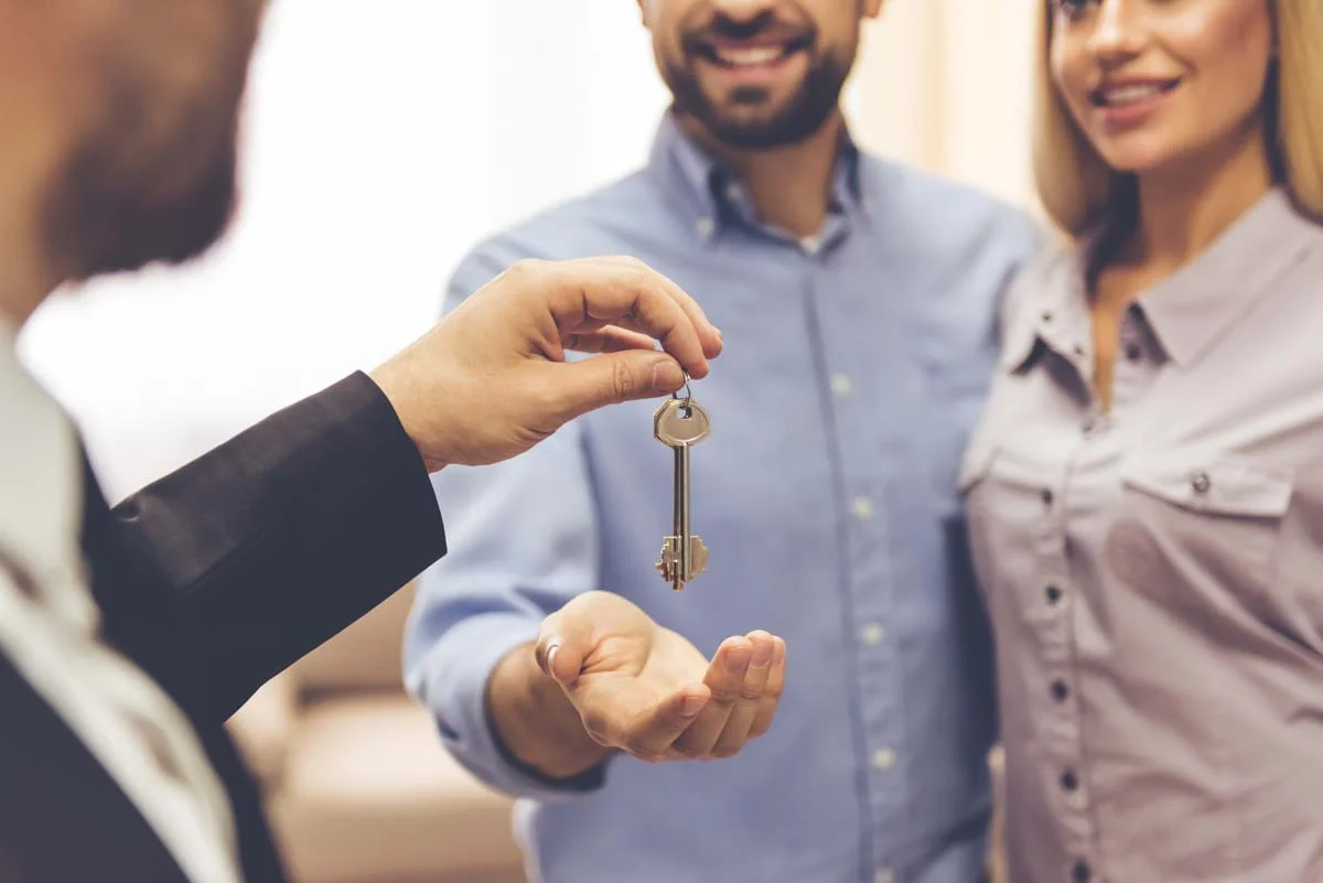 A professional property manager handing apartment keys to guests