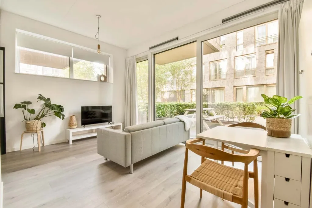 A modern and sunlit furnished apartment living room featuring stylish furniture and city views