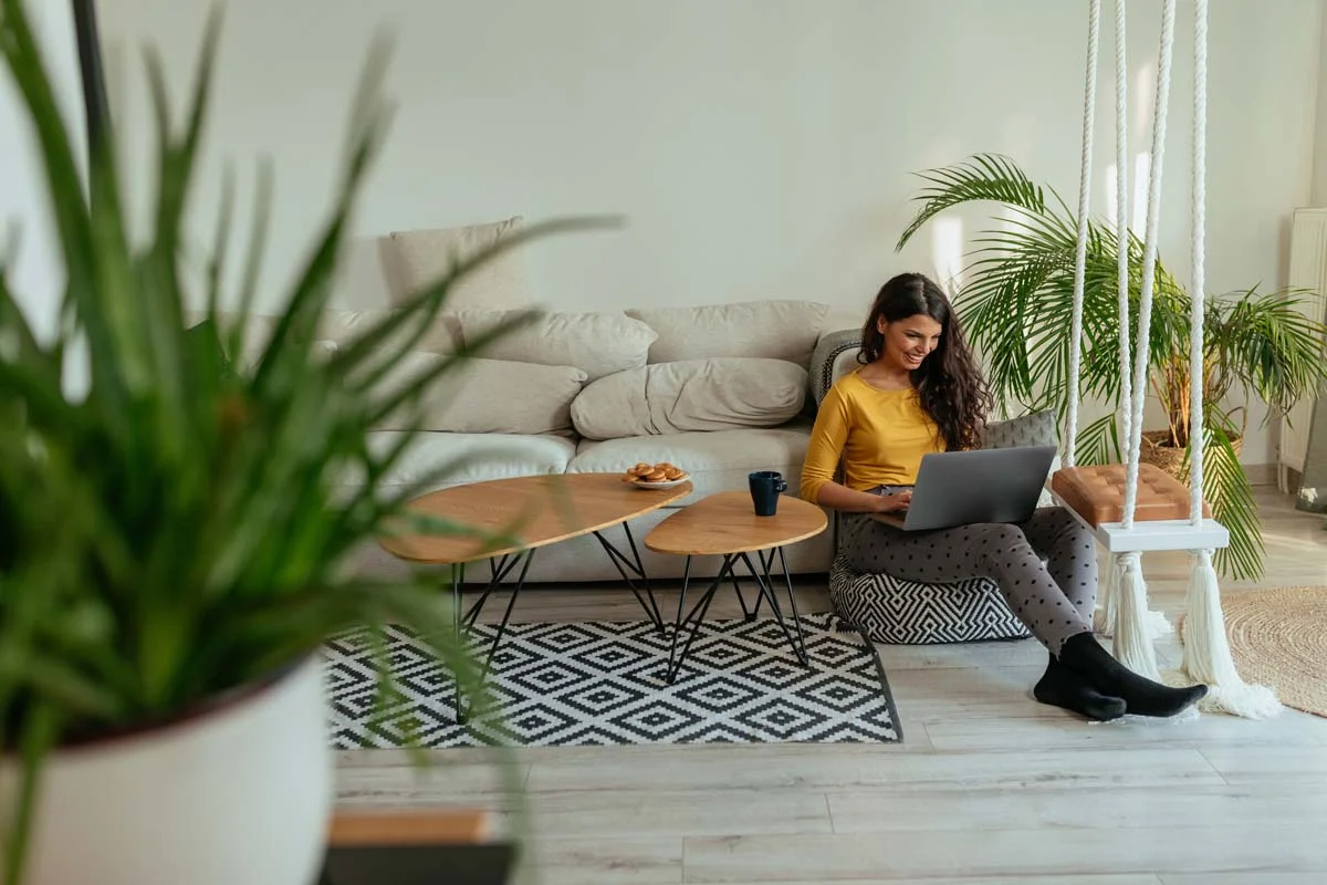 A professional working on a laptop in a cozy, fully furnished short-term rental apartment