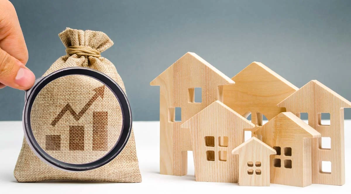 Money bag with chart up and wooden houses representing the concept of performance data and occupancy growth for an Airbnb portfolio