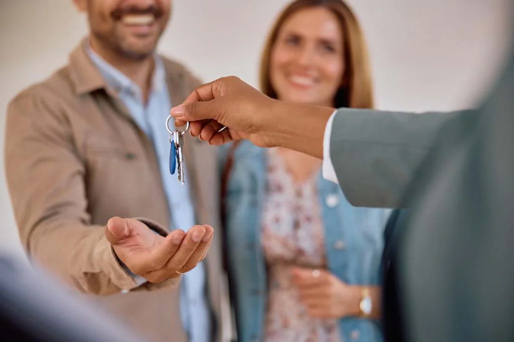 Close-up of a property manager handing house keys to a new client or guest