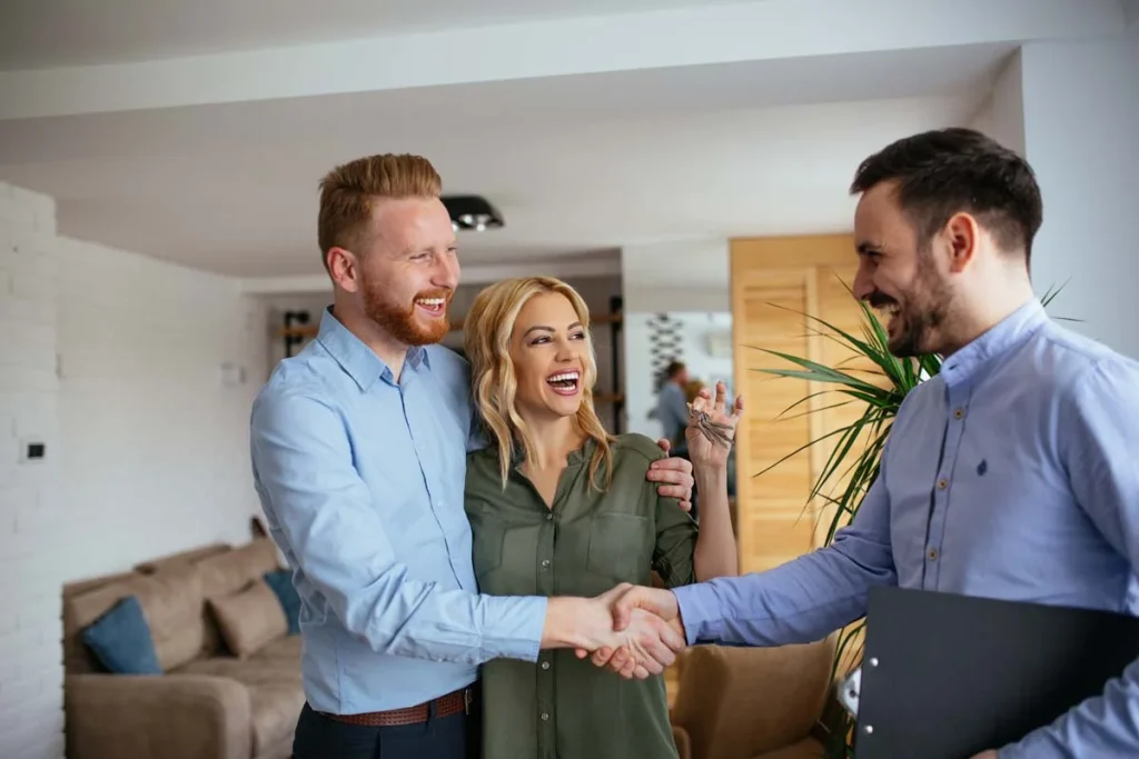Two people shaking hands in a bright room to start a professional property management partnership