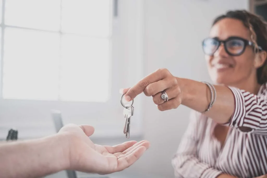 A close up of a person giving house keys to a new property manager.