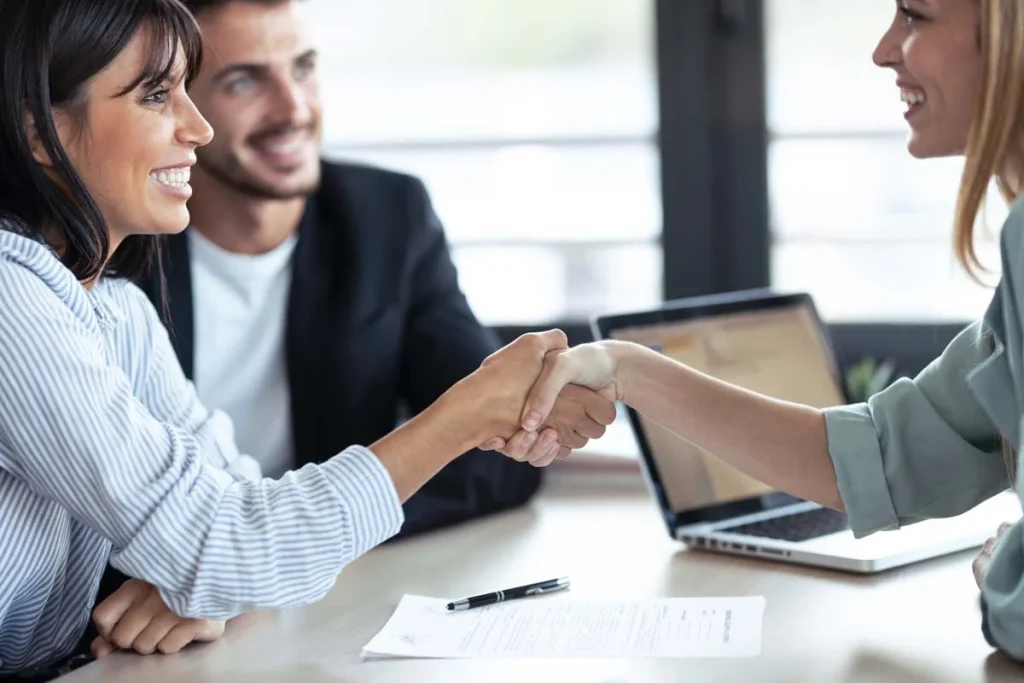 A close-up of a property owner and manager shaking hands to begin their Airbnb management partnership