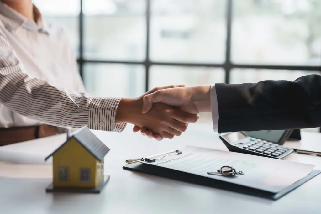 A homeowner and a property manager shaking hands to start a rental management partnership