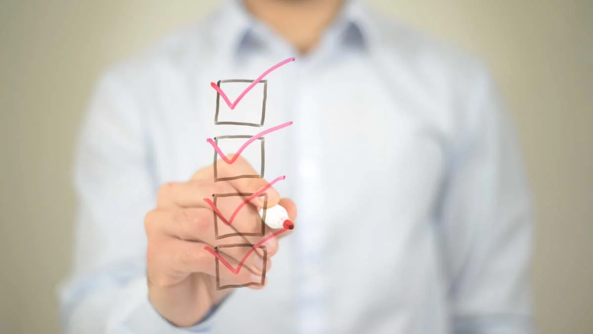 A person ticking off boxes, signifying a property compliance checklist for a short term rental