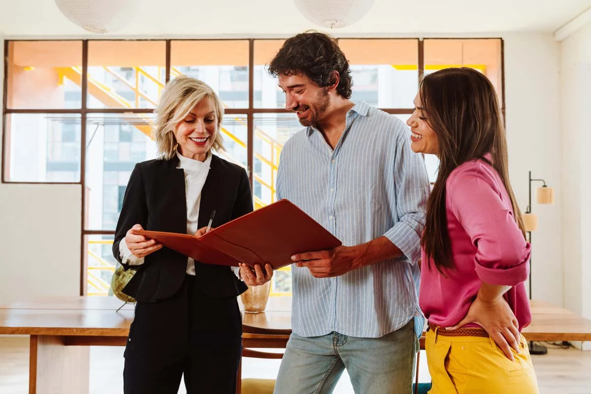 A property manager and owner in a clean and modern apartment, talking about their short-term rental partnership