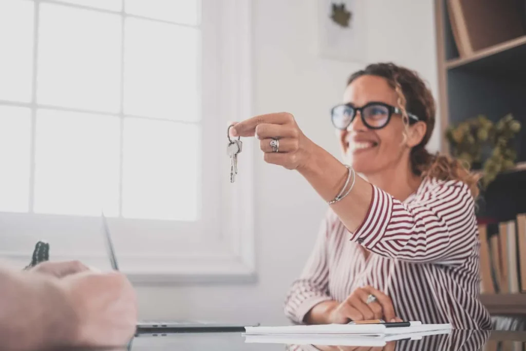 A property owner handing the housekey to her property manager for her short-term rental business