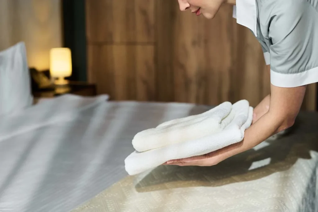 Fresh white linens and towels prepared by a professional cleaning team for a short-term rental