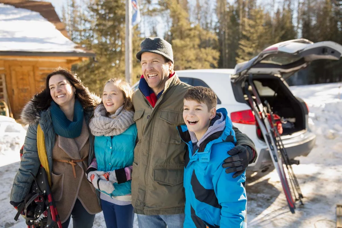 Happy travelers arriving at a modern tiny home in a lush British Columbia forest