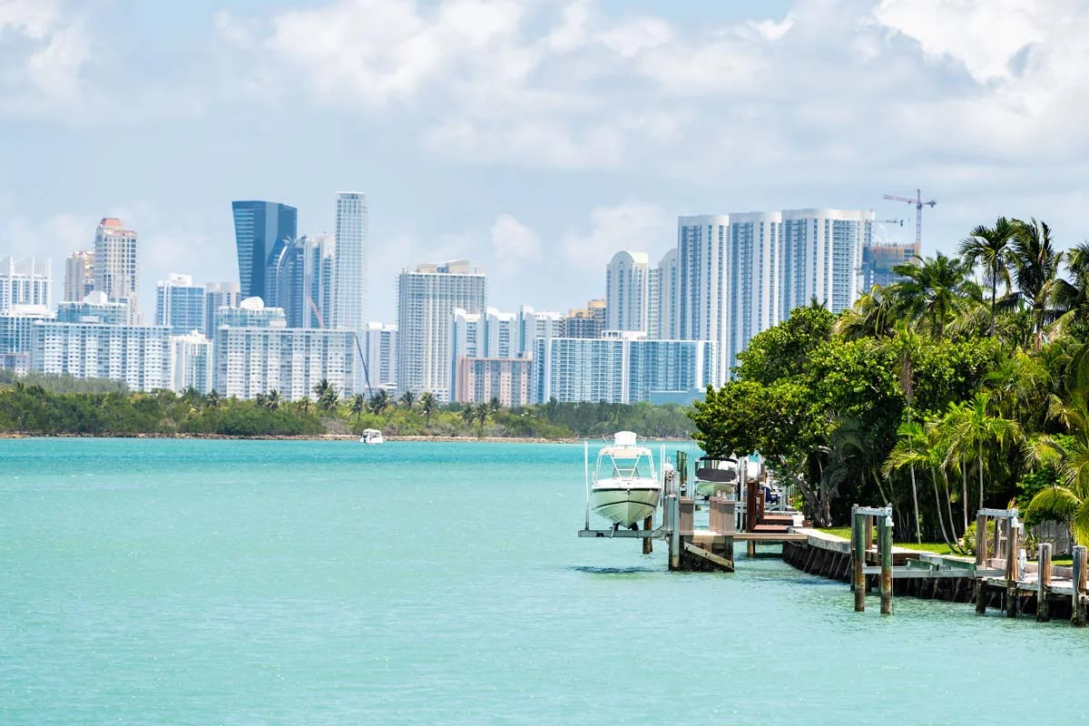 House dock with boat by light green turquoise ocean at Bal Harbour