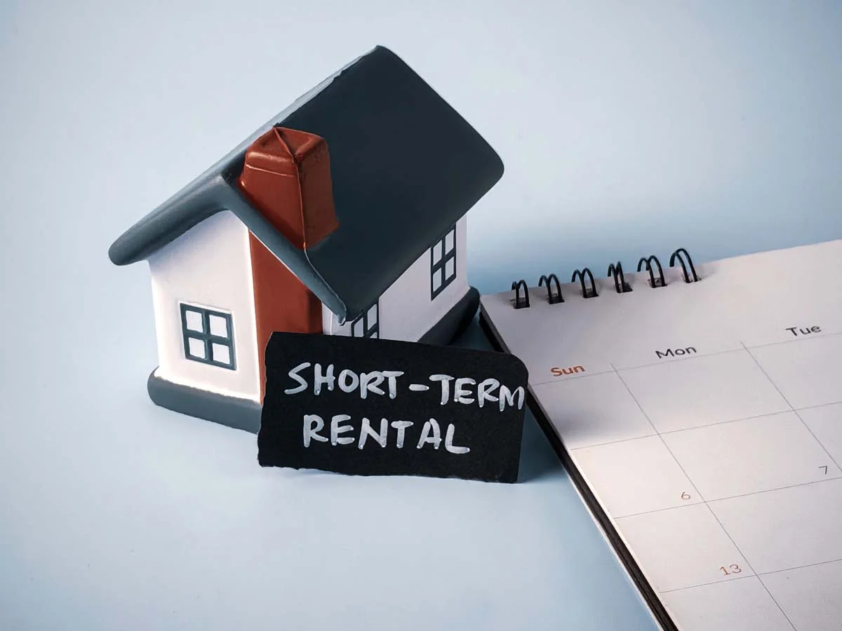 Miniature house and desk calendar with "short-term rental" 