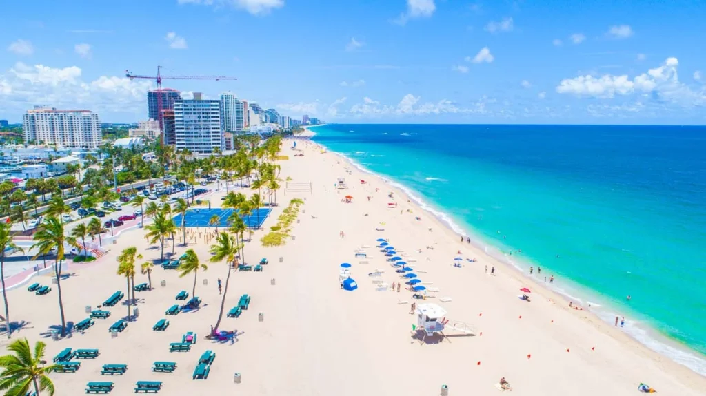 Sunny aerial view of luxury beachfront condos and palm trees in Broward County, Florida