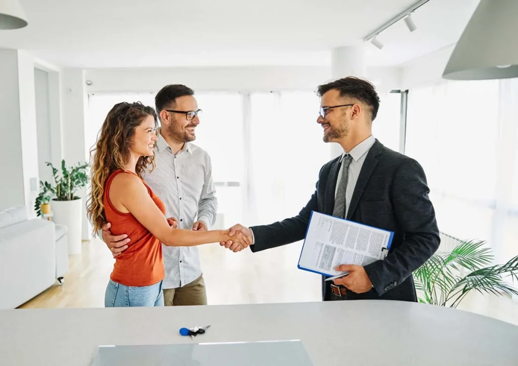 Two people shaking hands in a bright room representing a professional partnership