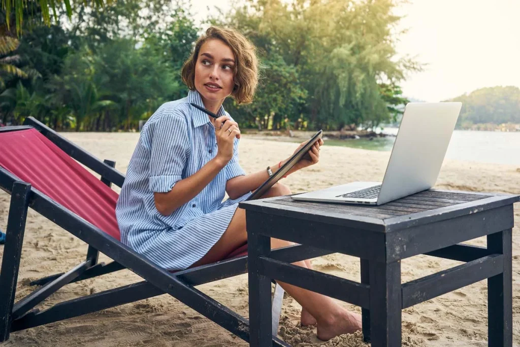 A digital nomad working remotely working over the blue sea beach of the Miami coast