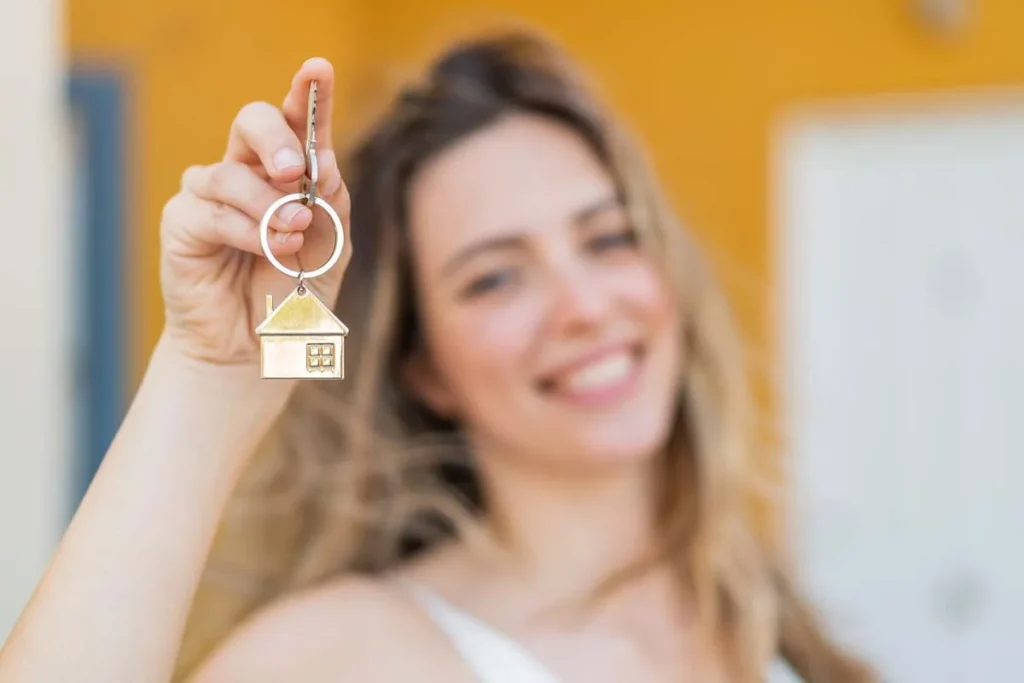 A happy homeowner holding house keys to a vacation rental property