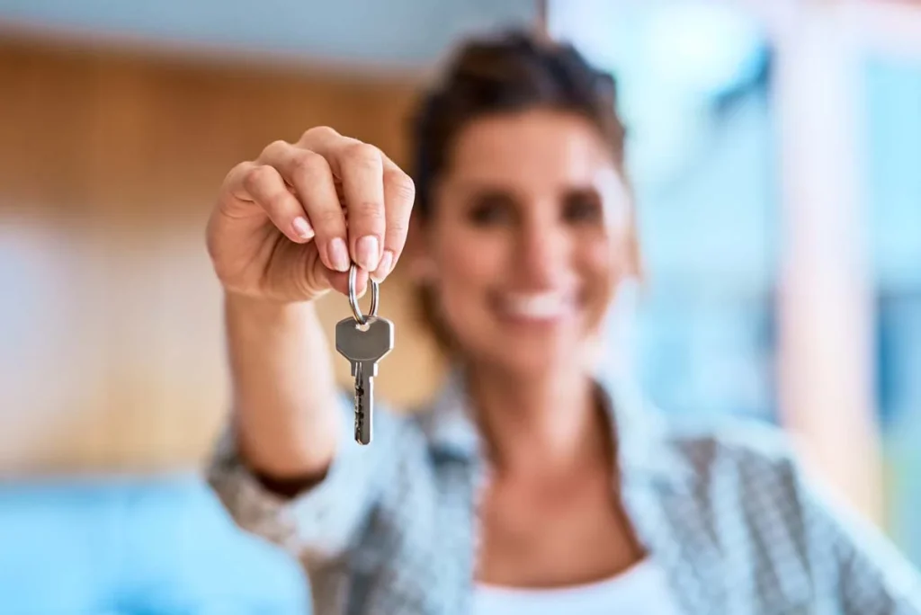 A happy property owner holding house keys to their vacation rental home