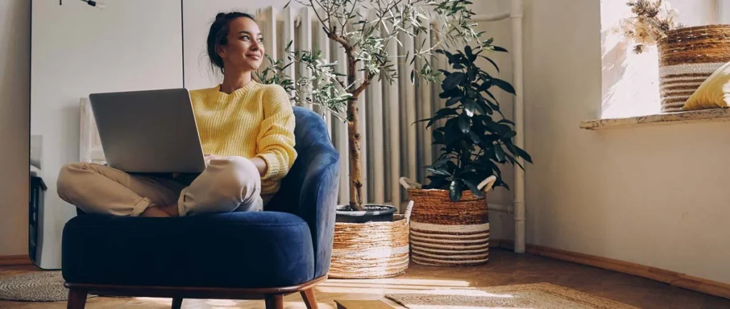 A happy property owner relaxing while checking their rental earnings on a laptop