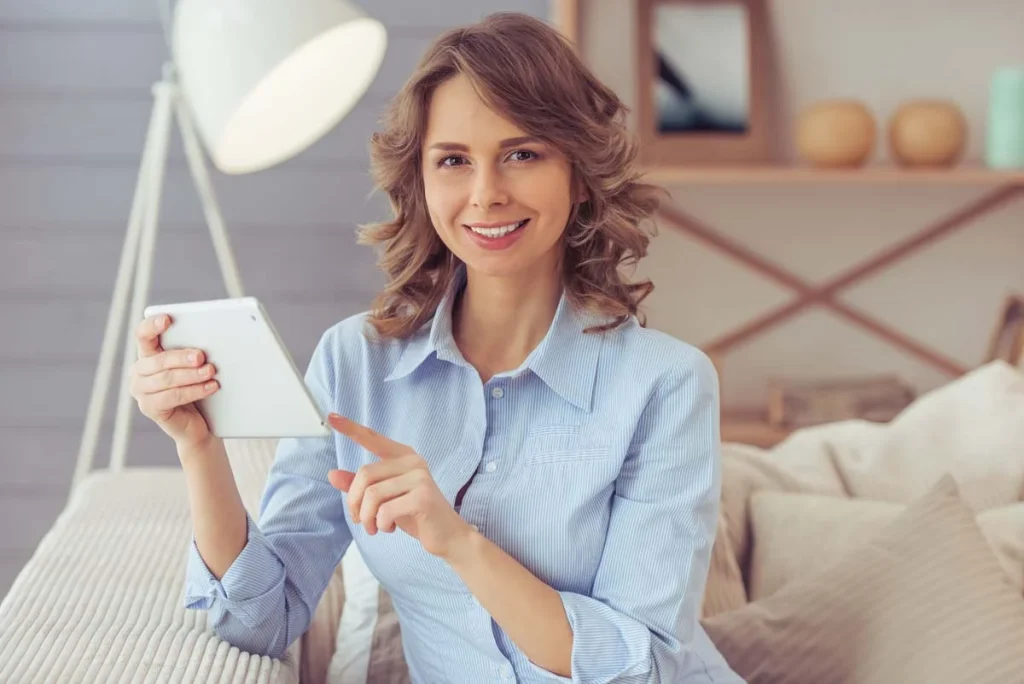 A happy property owner sitting comfortably at home while reviewing their rental performance on a tablet