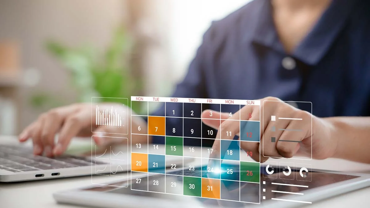 A person with a laptop and a calendar representing the registration and licensing process for short term rentals in Coral Springs