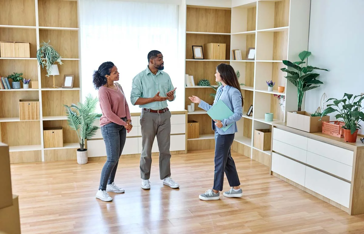 A professional property manager showing a pristine, professionally managed rental property interior to digital nomad guests