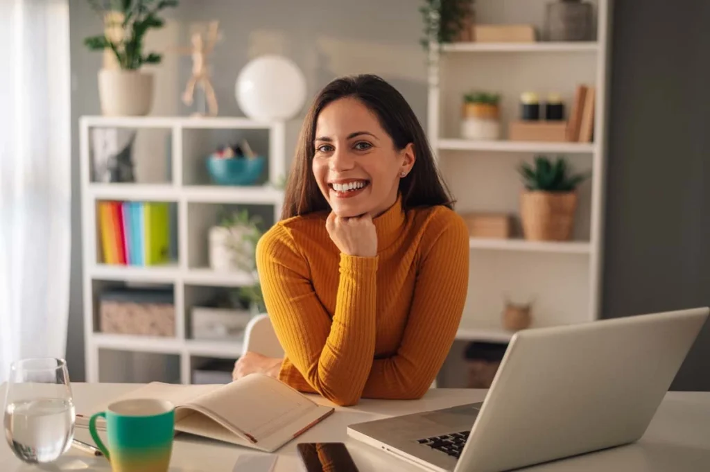 A professional property manager using a laptop and a calendar to manage a short-term rental listing inside a bright apartment