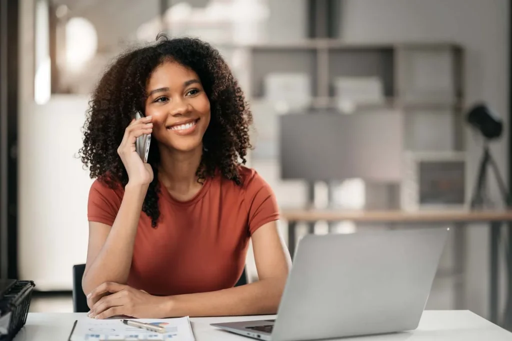 A relaxed property owner casually checking rental performance graphs on a laptop while enjoying a coffee in a comfortable home office setting