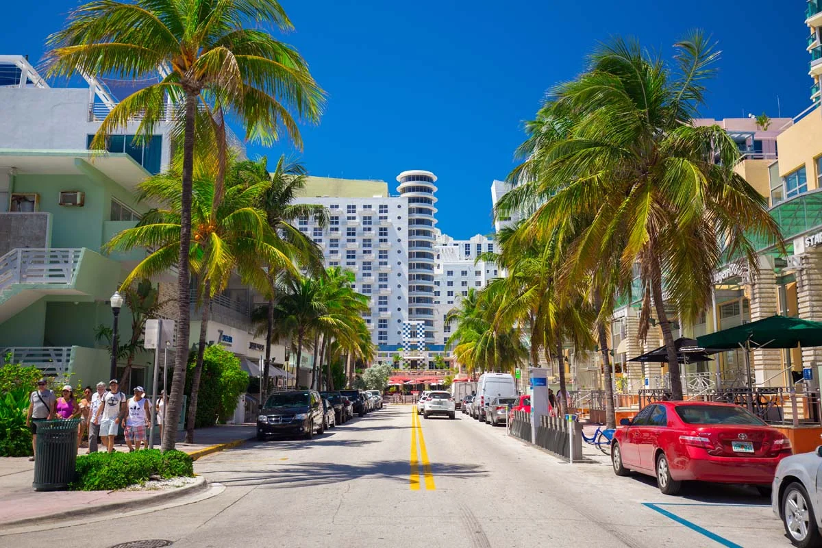 A sunny street view in a popular Miami neighborhood showing walkable streets, vibrant culture, and outdoor dining options for locals and visitors