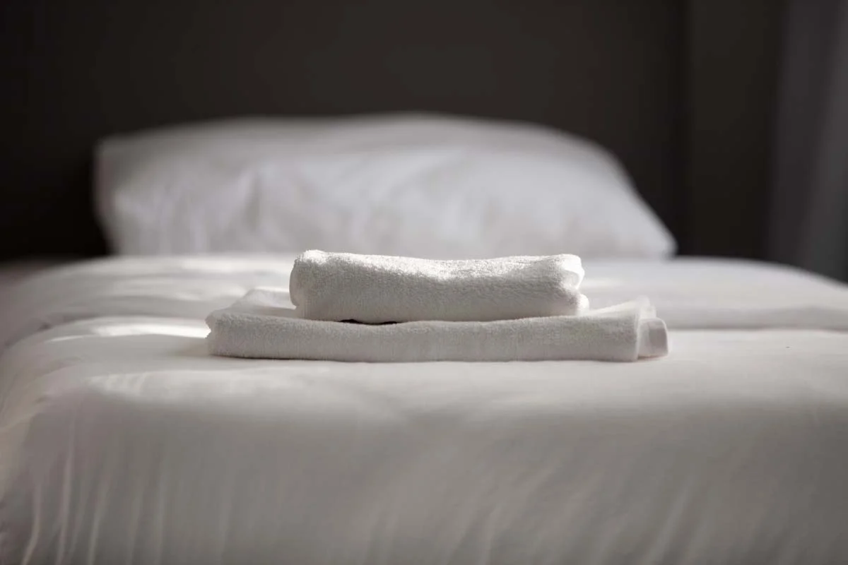 Clean white towels on a bed showing the high standards of Airbnb cleaning in Seattle