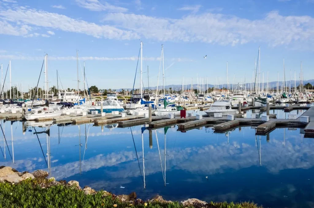 Luxury sailboats and yachts docked at a calm harbor in Oxnard California during the day