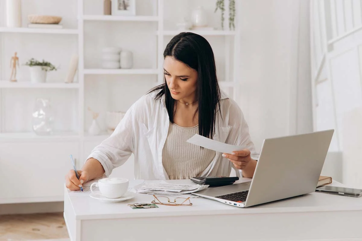 Property owner organizing vacation rental licensing documents on a modern desk