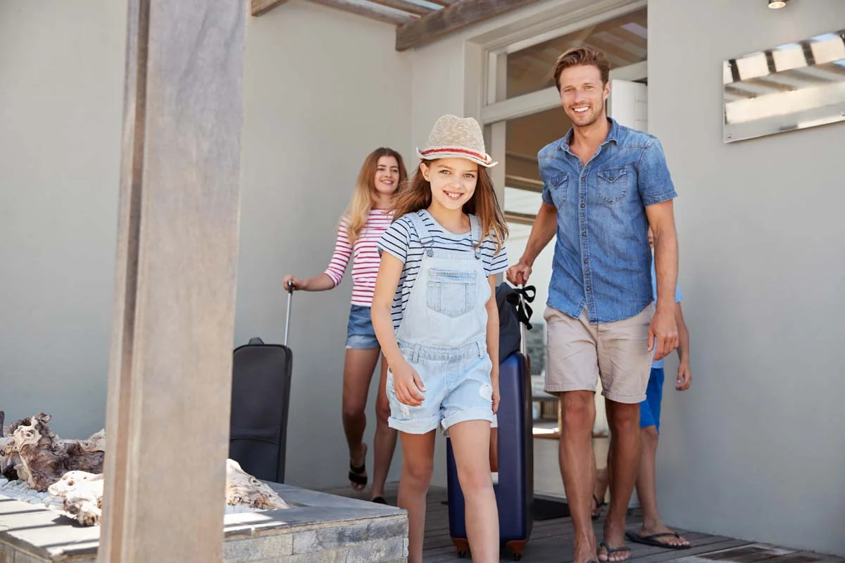 A happy family arriving at a vacation rental home for their stay