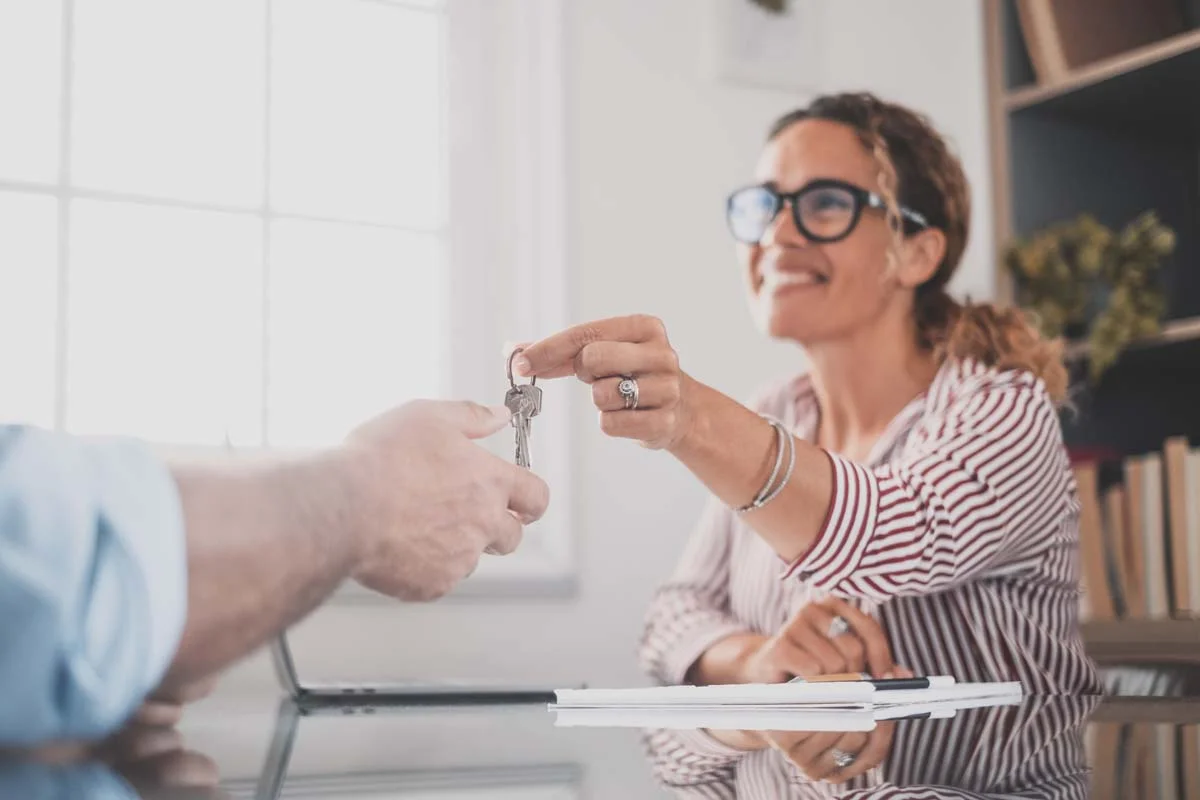 A person holding keys to a property, representing professional short-term rental management services