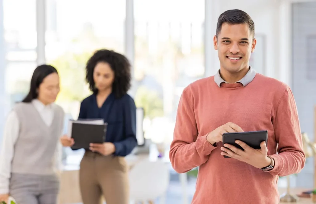 A professional property manager holding a tablet and smiling inside a high-quality rental property