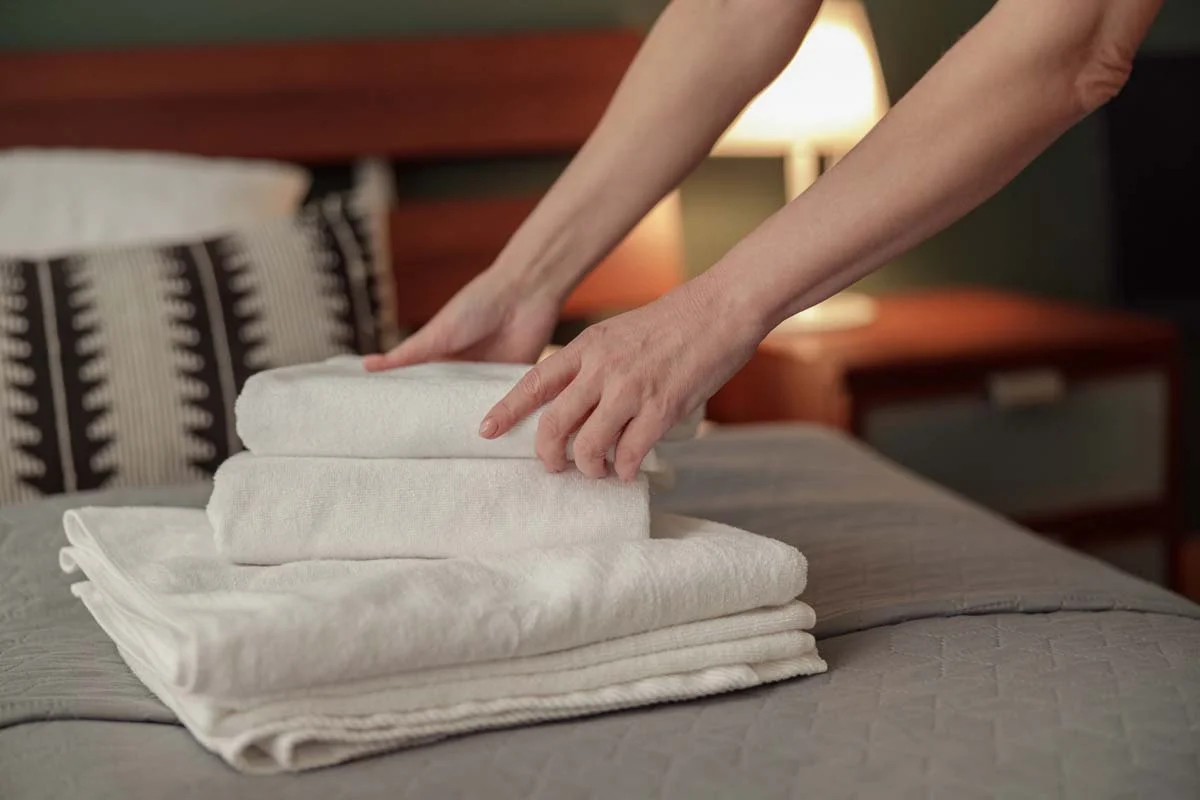 Close-up of fresh white towels and clean bed linen, showing the high standards of an Airbnb hosting service