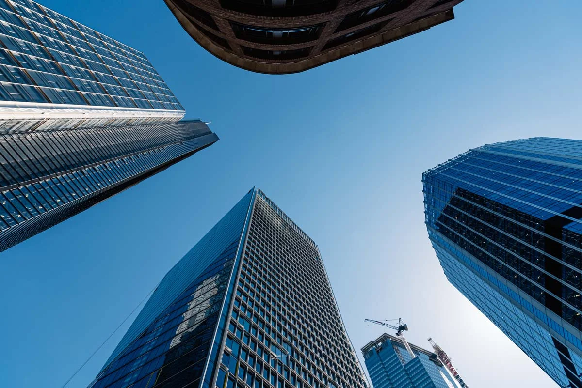 Modern glass residential high-rise condominium buildings reaching into a blue sky