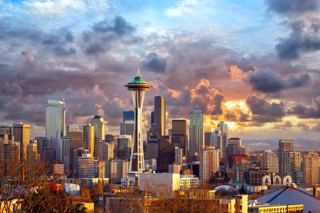 The Seattle city skyline and Space Needle at sunset with mountain views in the background