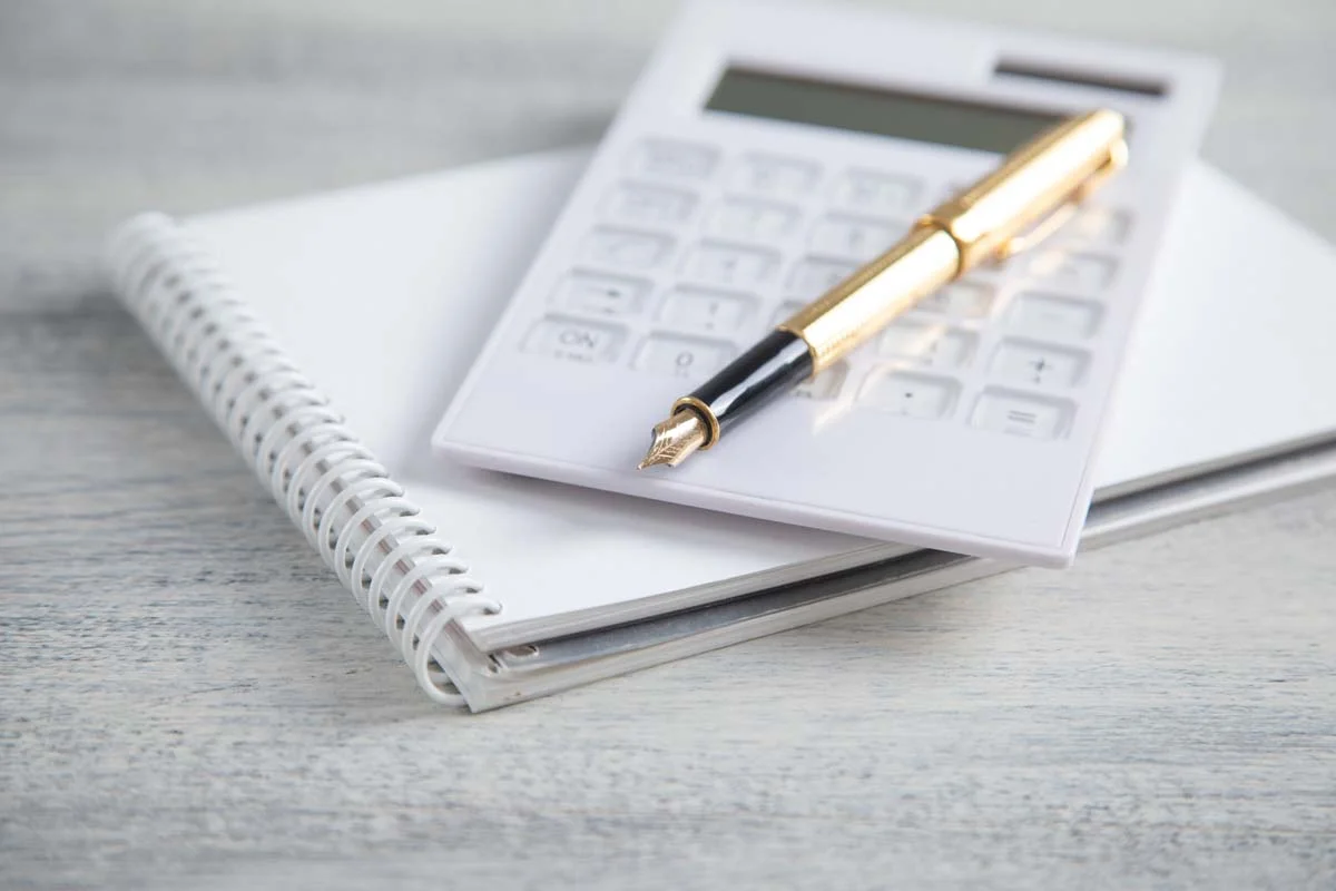 A calculator and notepad used to show how to calculate NOI for rental property