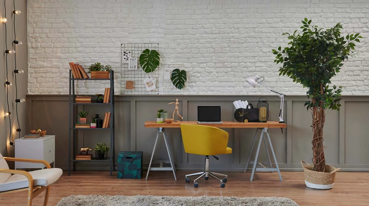 A modern home office desk with a laptop and plant, ideal for mid term rentals in Los Angeles