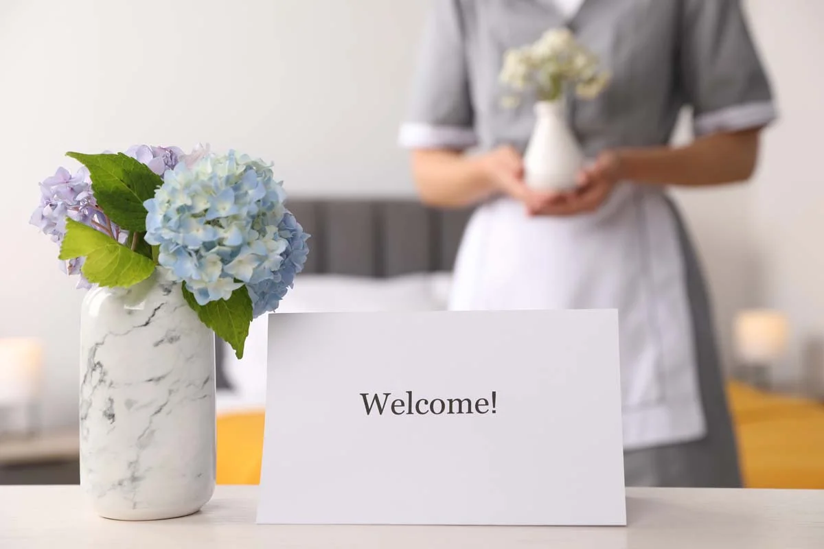 A professional welcome card for guests on a clean white desk in a short-term rental