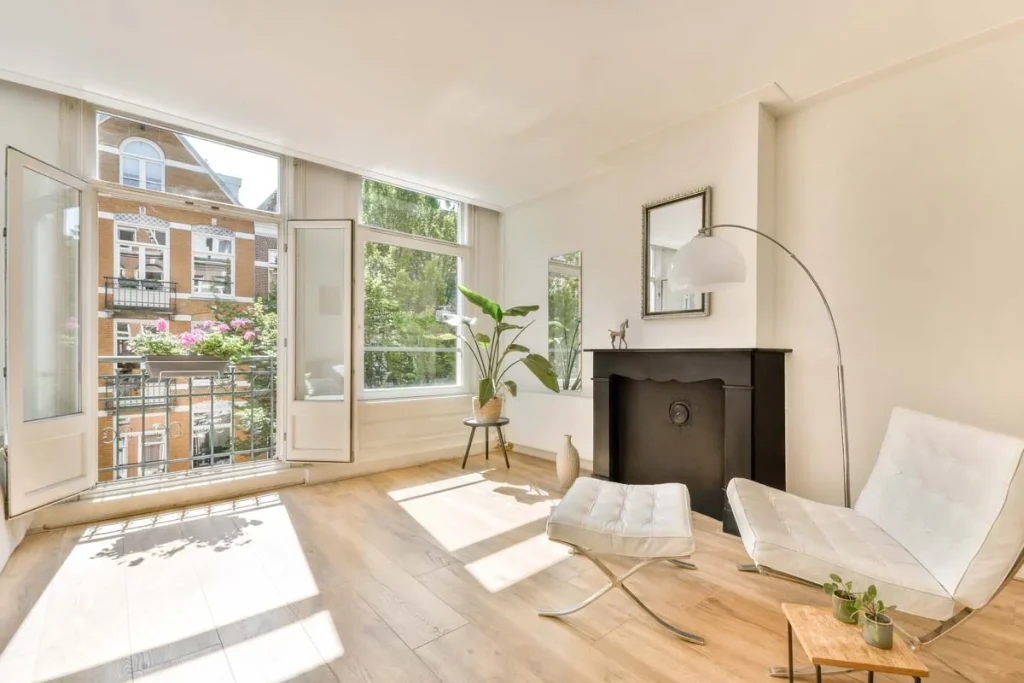 A bright, modern furnished apartment interior with large windows showing trees