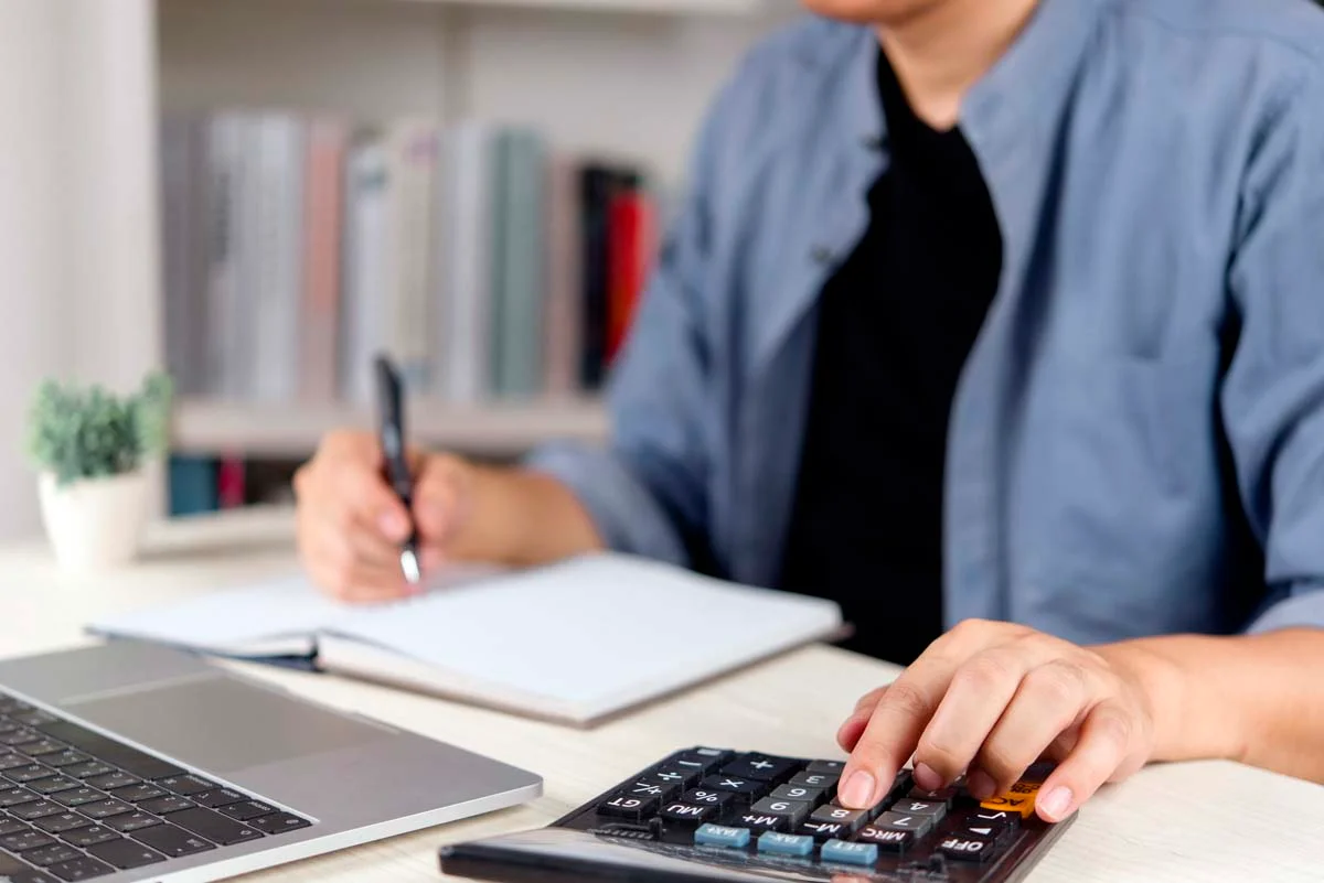 A calculator and a notebook on a desk for property budget planning