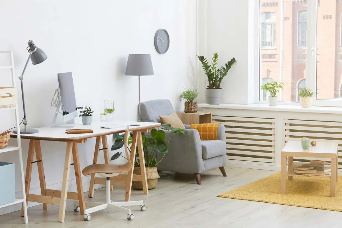 A clean, dedicated workspace setup with a laptop and ergonomic chair inside a modern rental apartment
