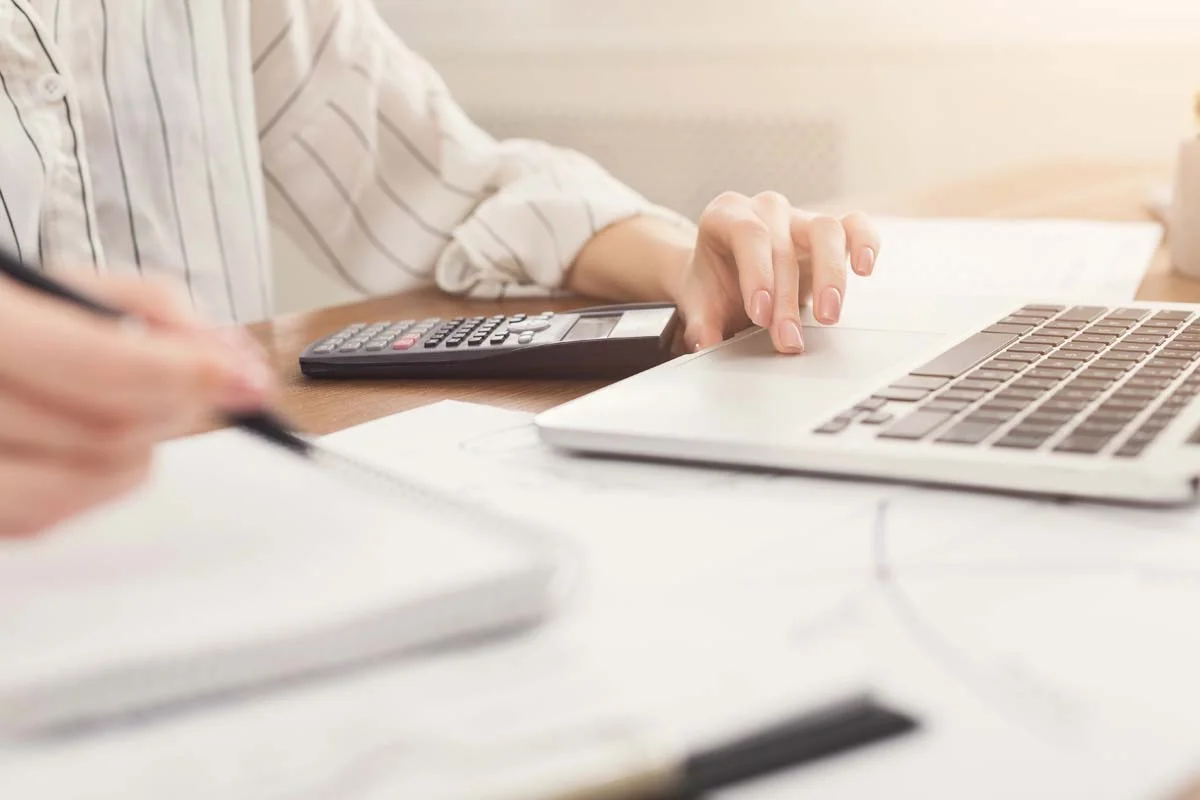 A homesharing host working on a laptop to adjust their pricing and availability calendar