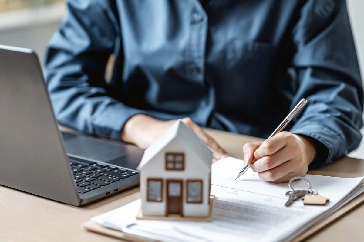 A laptop and house keys on a desk representing the application process for a short term rental permit