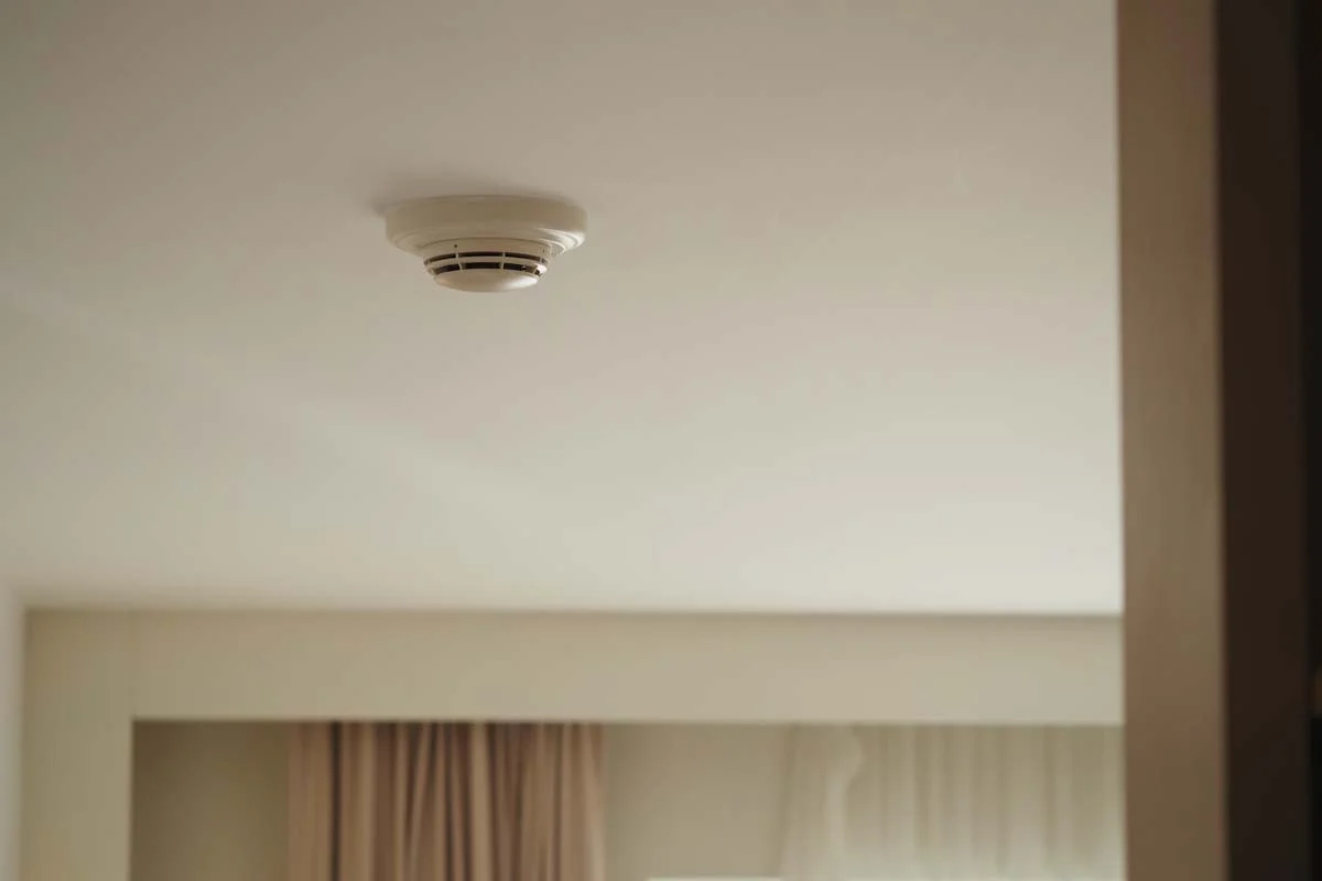 A modern, clean home interior featuring a properly installed ceiling smoke detector
