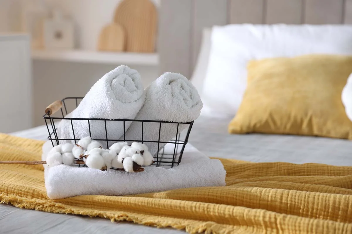 A neatly prepared guest bed with fresh white towels in a vacation rental
